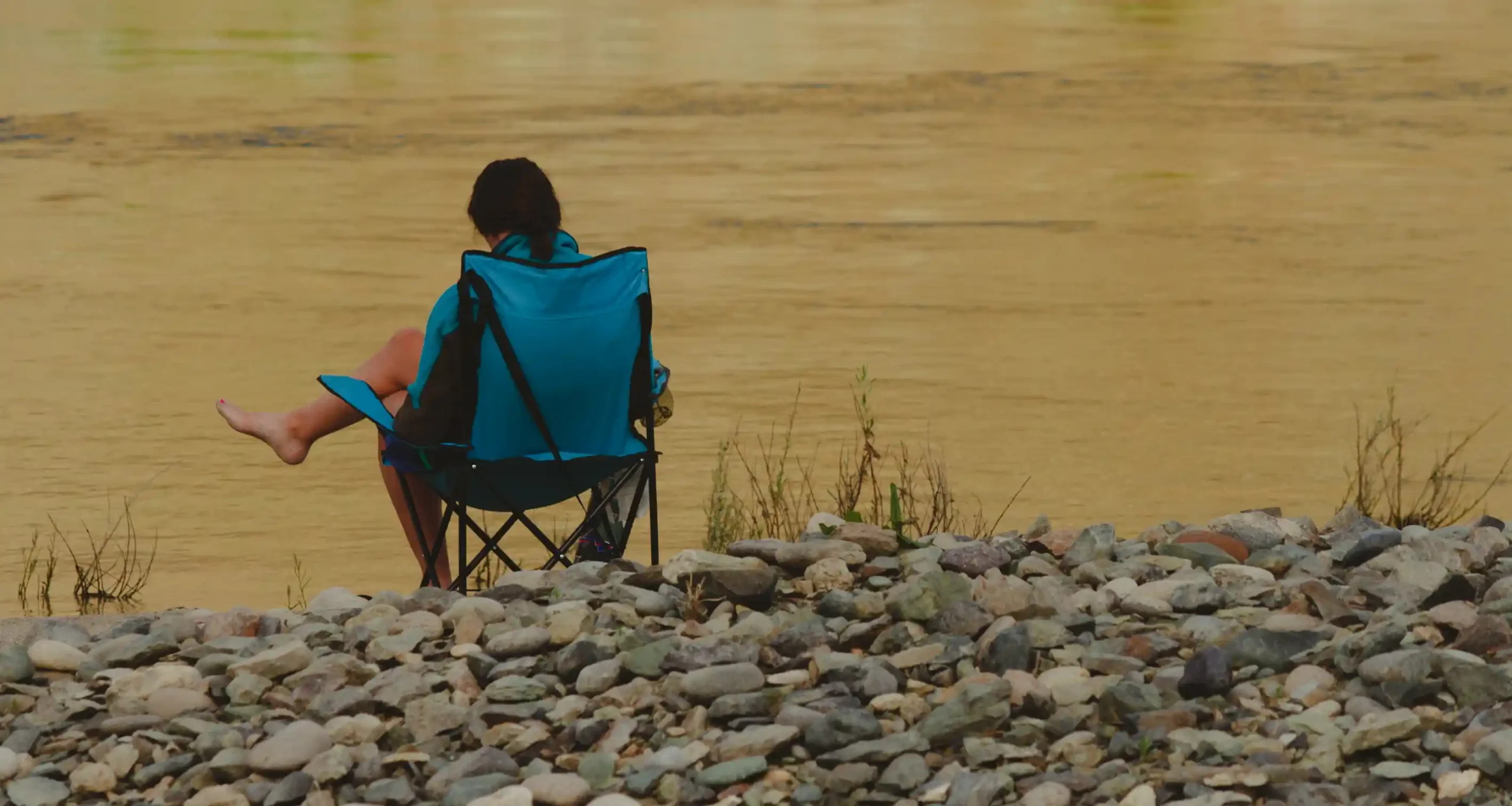 Woman sitting in front of river