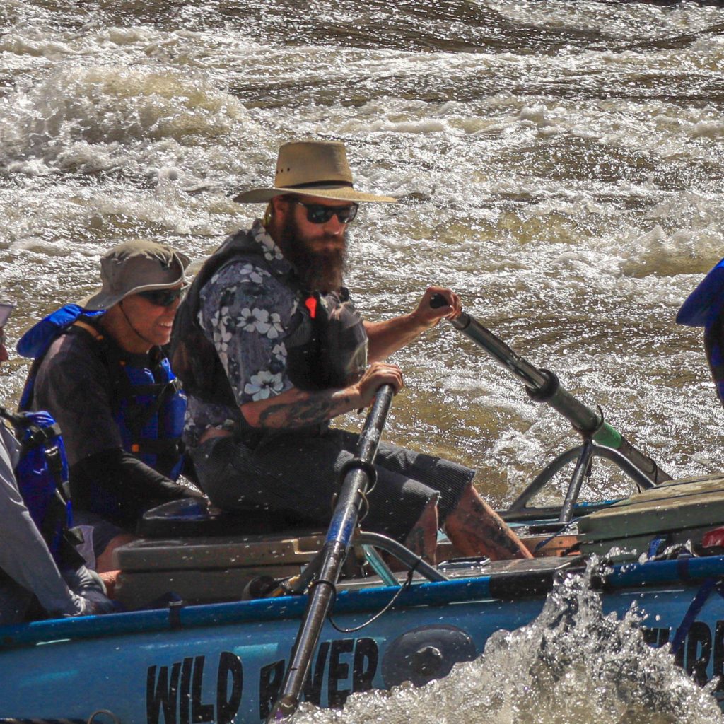 Man steering boat on river