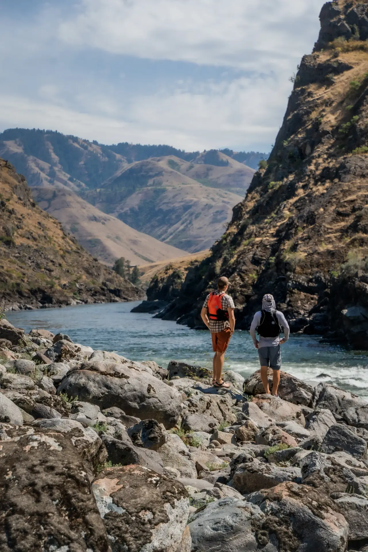 Two men enjoying the scenery on the side of the river