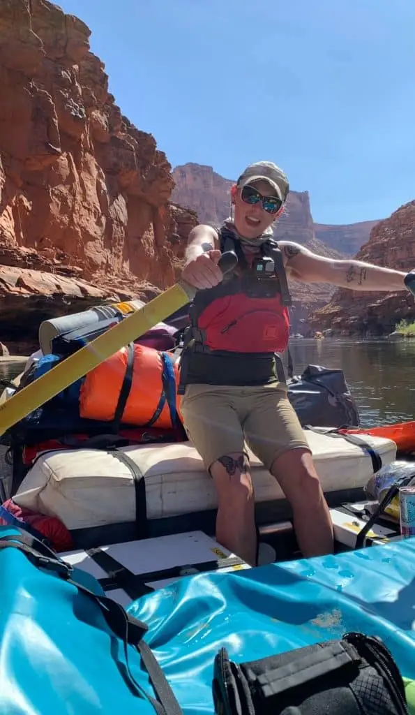 Woman rowing a boat down a canyon river